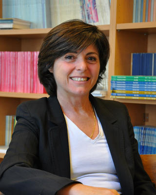 Headshot of Riva Kastoryano smiling in front of a bookshelf