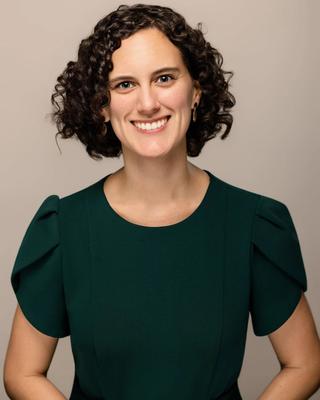 Headshot of Elena Ayala-Hurtado in front of a beige background