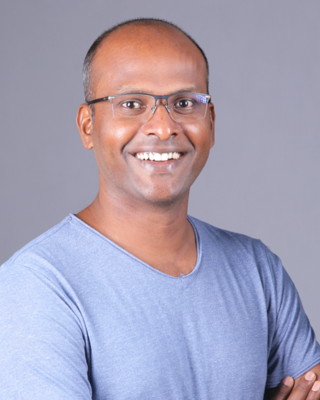 Senthil Nathan headshot in front of a grey background