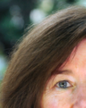 Headshot of Diane Davis standing outside against trees