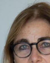 Headshot of Jacqueline Bhabha in front of a blurred background