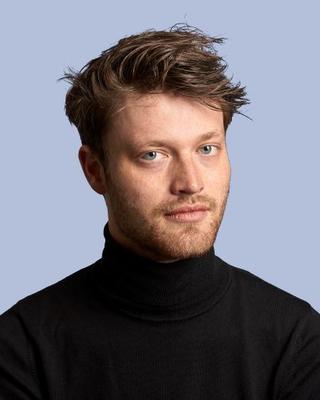 Headshot of Luuc Brans against a light blue background