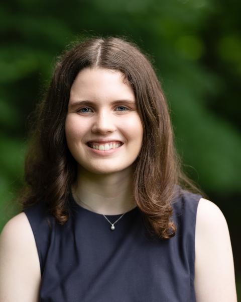 Headshot of Sydney Black in front of a background with trees