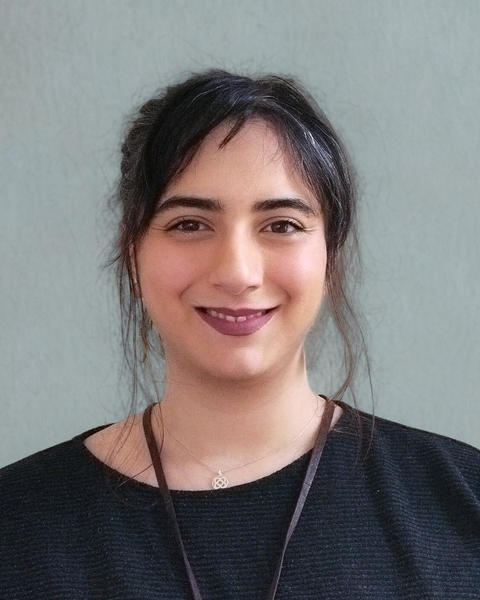 Headshot of Gulce Ozedmir in front of a blue-green background