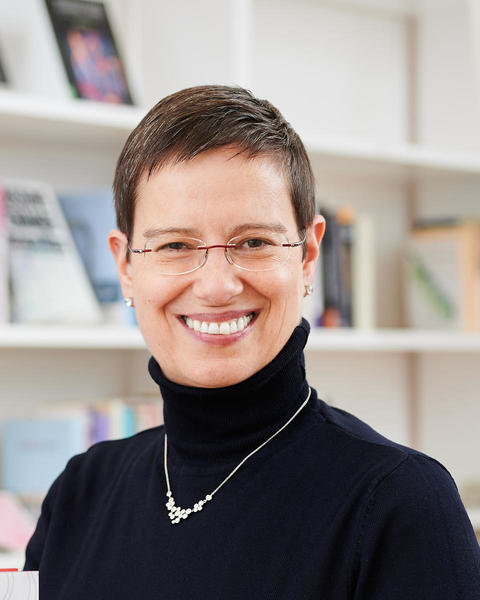 Headshot of Ayelet Shachar in front of shelves with books