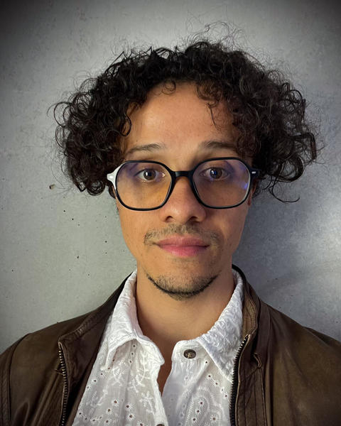 Headshot of Livio Silva-Muller in front of a grey background