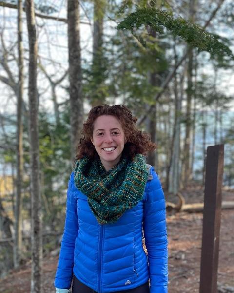 Headshot of Mariam Gleckman-Krut situated against a background of trees. 