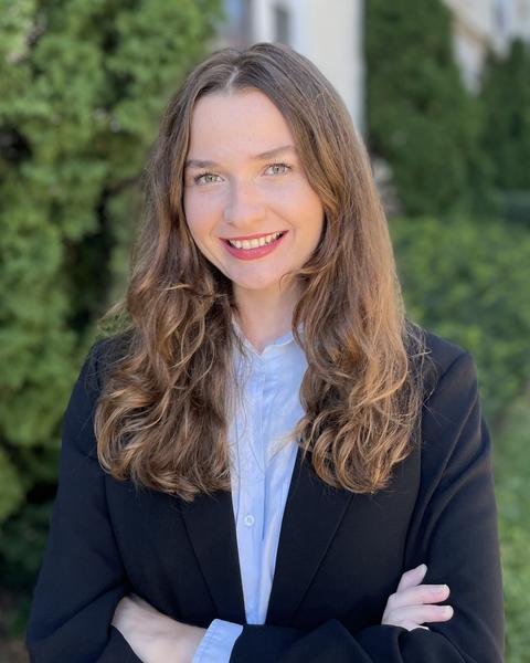 Headshot of Yasemin Girgin in front of bushes and other greenery