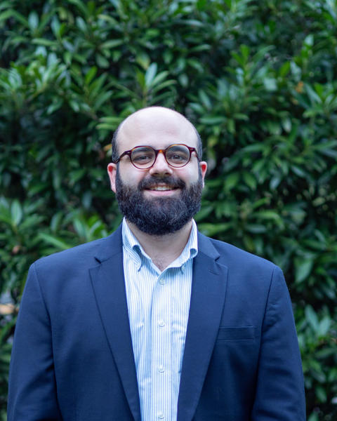 Headshot of Peter Habib standing in front of greenery