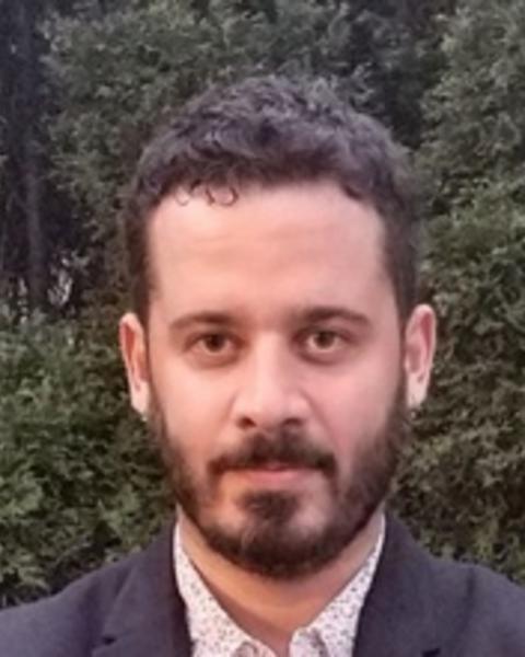 Headshot of Ruy de Deus e Mello in front of greenery