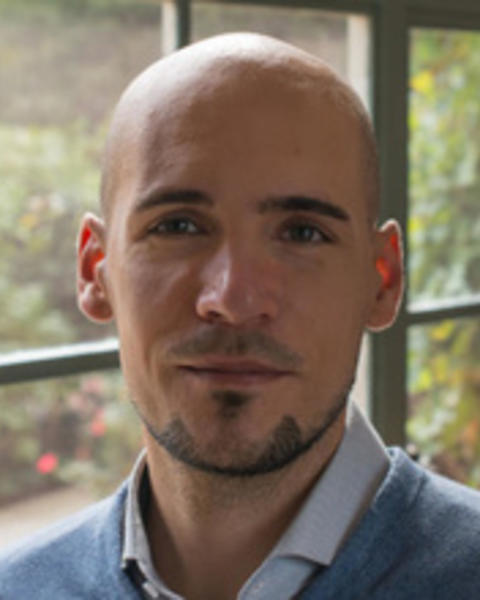 Headshot of Stefan Beljean standing by a window