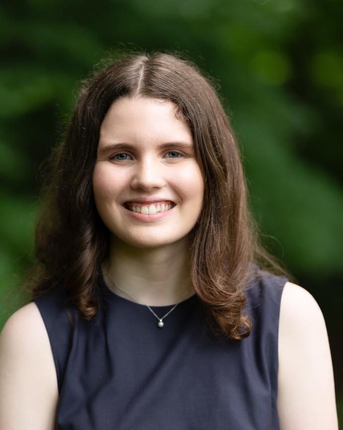 Headshot of Sydney Black in front of a background with trees