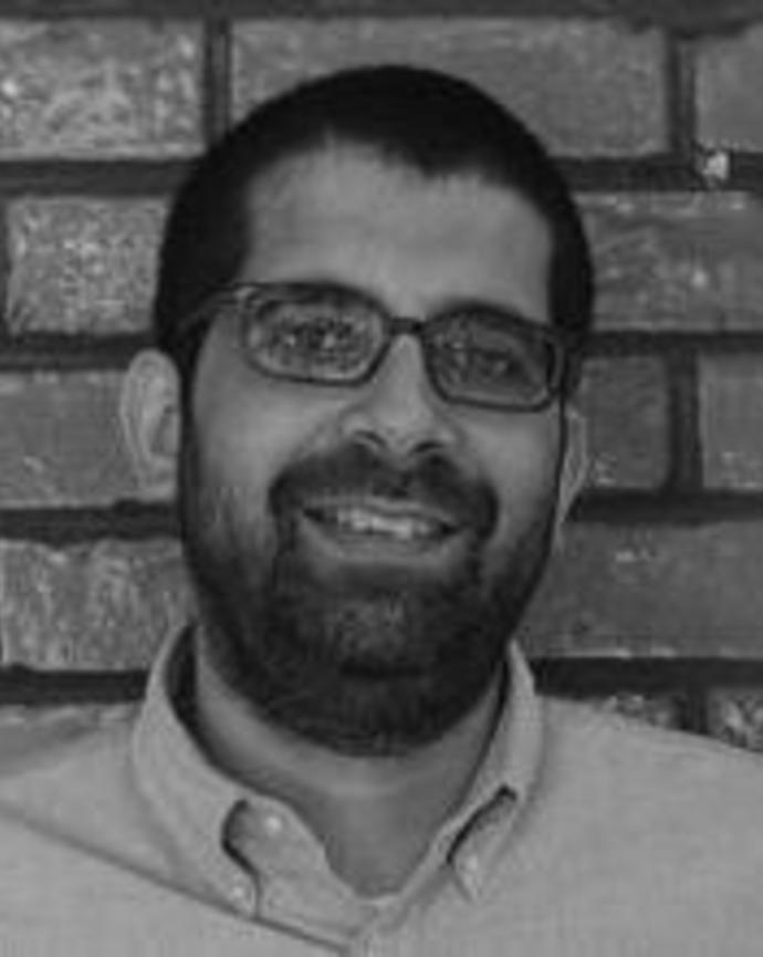 Headshot of Puneet Bhasin in front of a brick wall