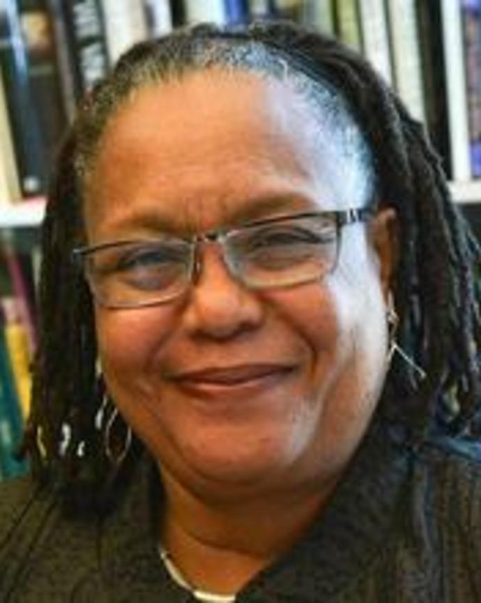 Headshot of Evelynn Hammonds sitting in front of book shelves and smiling