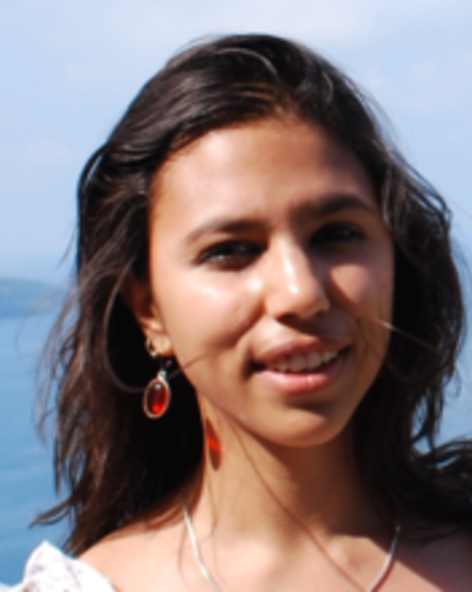 Headshot of Poulomi Chakrabarti standing outside by water
