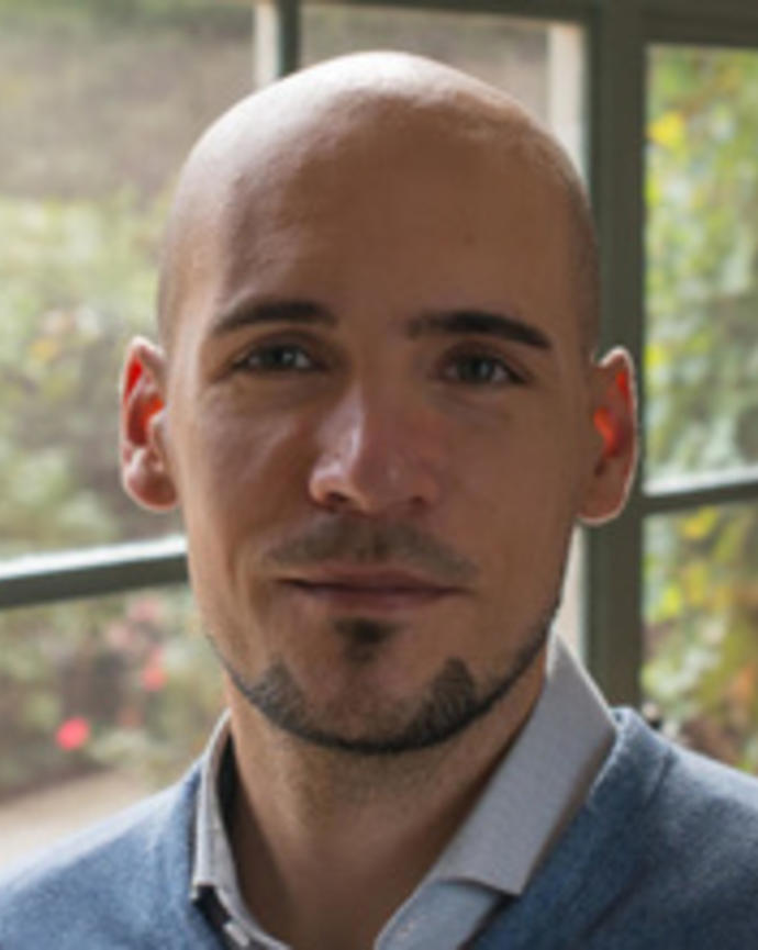 Headshot of Stefan Beljean standing by a window