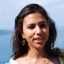 Headshot of Poulomi Chakrabarti standing outside by water